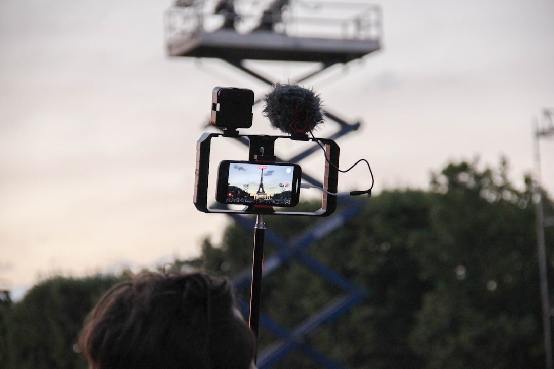 Camera operator filming a live outdoor event with a broadcast camera